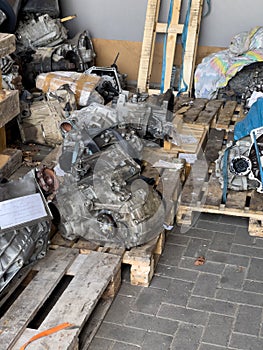 Repaired engine gearboxes lie on wooden pallets in the shed