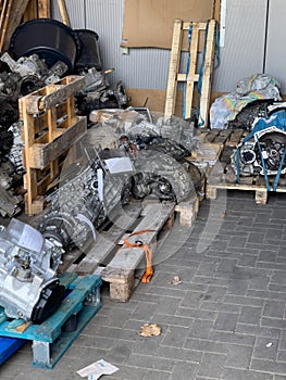 Repaired engine gearboxes lie on wooden pallets in the shed