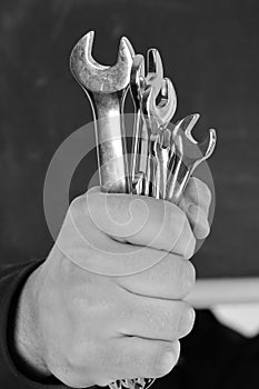 Repairer or mechanic hand holds spanner instrument.