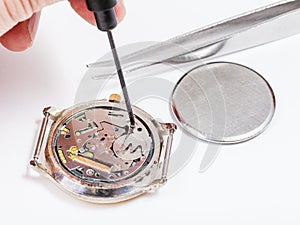 Repairer replaces battery in quartz watch close up