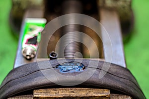 Repairing bicycle tube In workshop. Close up image of glue to repair inner tube of bicycle wheel. The mechanic does his job