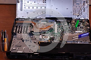 Repairing a broken laptop, unscrewing screws with small screwdrivers