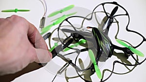 Repairing drone quadcopter in service, man fixing propellers