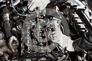 Repairing of modern diesel engine, workers hands and tool. Close-up of an auto mechanic working on a car motor