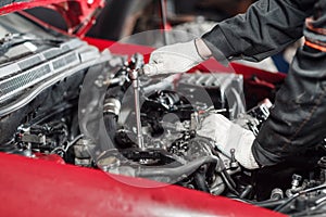 Repairing of modern diesel engine, workers hands and tool. Close-up of an auto mechanic working on a car motor