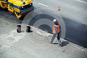 Repairing of road section. Worker in orange vest.