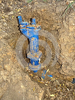 Repairing of water delivery system. Trench with pipes under house