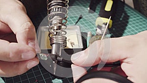 Repairing of a wire for electronic devices. Male hands soldering wire
