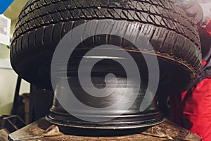 Repairman balances the wheel and installs the tubeless tire of the car on the balancer in the workshop.