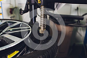 Repairman balances the wheel and installs the tubeless tire of the car on the balancer in the workshop.