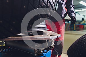 Repairman balances the wheel and installs the tubeless tire of the car on the balancer in the workshop.