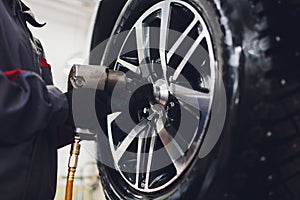 Repairman balances the wheel and installs the tubeless tire of the car on the balancer in the workshop.