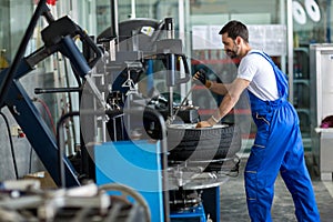 Repairman balancing car wheel on balancer