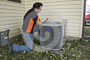 Repairman Checking Outside Air Conditioning Unit For Voltage