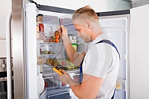 Repairman Checking Refrigerator photo