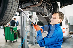 Repairman checks the suspension, car on the lift