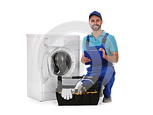 Repairman with clipboard and toolbox near washing machine on background