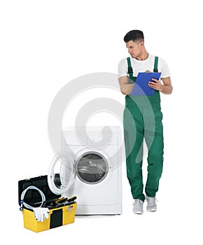 Repairman with clipboard and toolbox near washing machine on background