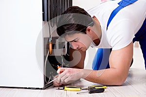 The repairman contractor repairing fridge in diy concept