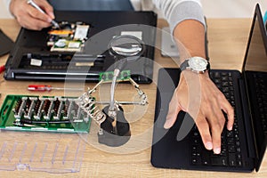 repairman disassembling laptop motherboard
