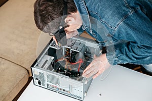 Repairman is disassembling personal computer. Engineer is diagnostic and fixing broken pc in workshop.