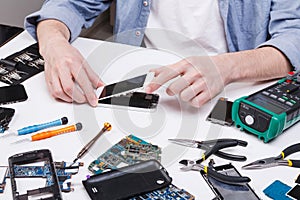 Repairman disassembling phone for inspecting