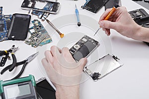 Repairman disassembling phone with screwdriver