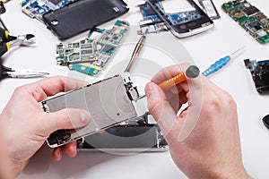 Repairman disassembling phone with screwdriver