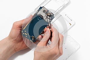 Repairman disassembling smartphone with tweezers