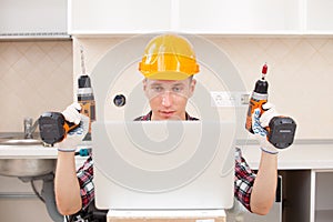 Repairman with a drill near a computer