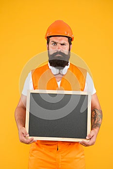 Repairman engineer hold blackboard copy space. Handsome repairman. Man bearded repairman builder work clothes. Plan