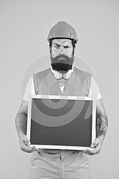 Repairman engineer hold blackboard copy space. Handsome repairman. Man bearded repairman builder work clothes. Plan