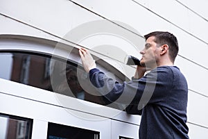 Repairman Examining The Edge Of Closed Door With Torch