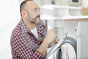 repairman examining washing machine