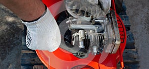 Repairman fixes the lawn mower engine with tools at the workshop