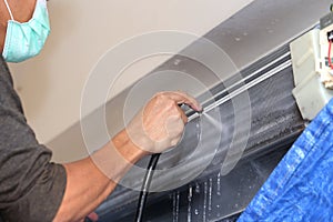 Repairman fixing and cleaning air conditioner unit