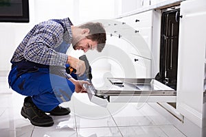 Repairman Fixing Dishwasher