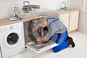 Repairman Fixing Dishwasher photo