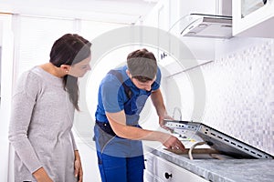 Repairman Fixing Induction Stove In The Kitchen