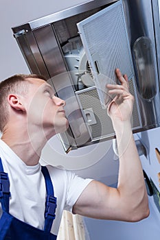 Repairman fixing kitchen extractor fan