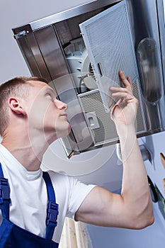 Repairman fixing kitchen extractor fan photo
