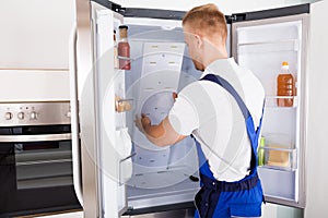Repairman Fixing Refrigerator