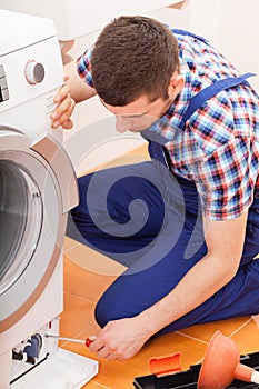 Repairman fixing washing machine