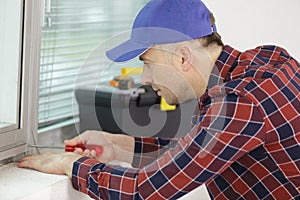 repairman fixing window frame in room