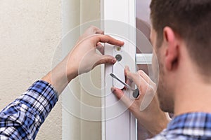 Repairman Fixing Window With Screwdriver