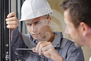 repairman fixing window with screwdriver