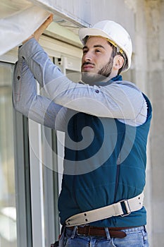 repairman fixing window with screwdriver