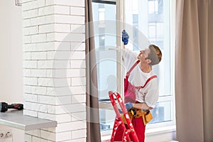 A repairman fixing windows in new apartment.