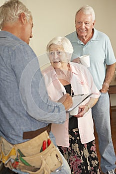 Repairman Giving Senior Couple Estimate For Repair