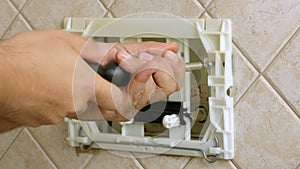 Repairman hands unscrewing a screw flush toilet box to fix bathroom closeup video